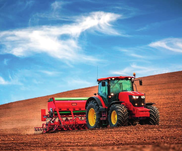 A tractor pulling a seed drill